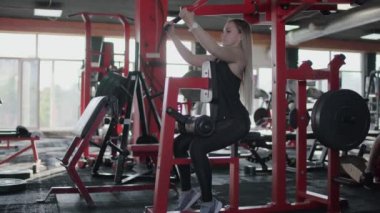 Sarışın kadın jimnastik salonunda egzersiz yapıyor.