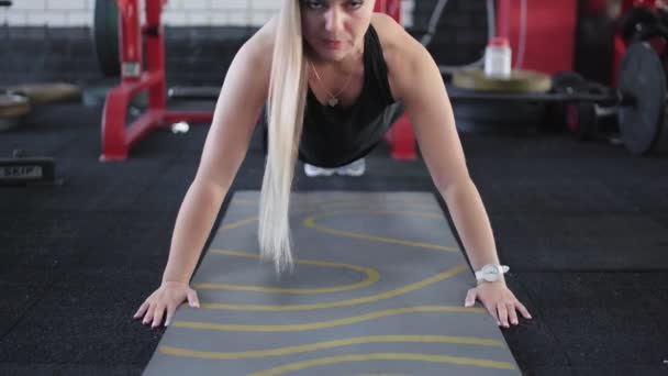 Mladá blondýna žena dělá Push-up cvičení v tělocvičně — Stock video