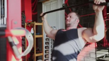 Çekici bir vücut geliştirme ustası spor salonunda Lat-down yapıyor.