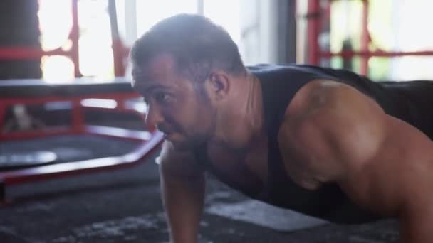 Um homem atraente fisiculturista realizando exercício Push-up no ginásio — Vídeo de Stock