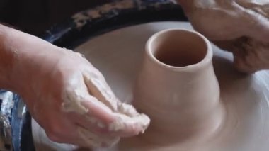 Potter çömlekçide çömlek aletleriyle killi ürünü şekillendirir.