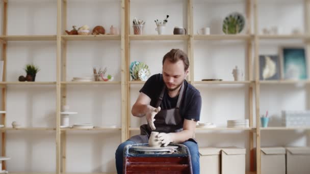 Hombre alfarero moldeando pieza de arcilla en la mesa. Hombre haciendo artículo de cerámica. Trabajo de cerámica, habilidades hechas a mano y creativas en el estudio de artes. — Vídeo de stock