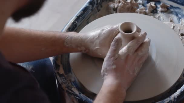 Trabaja a mano en la rueda de cerámica, dando forma a una olla de barro, estudiante hacer de olla de barro en el estudio — Vídeo de stock
