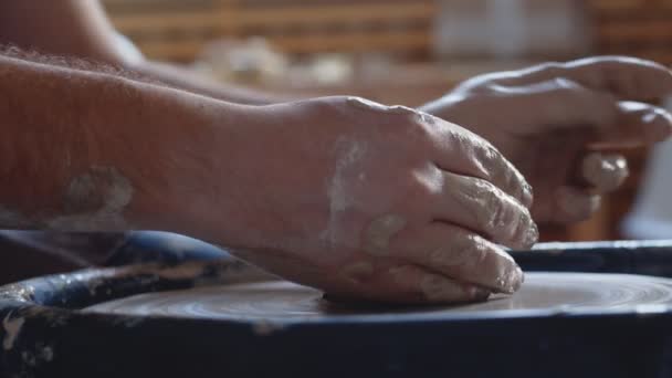 Seitenansicht der Hände, die an der Töpferscheibe arbeiten und einen Tontopf formen — Stockvideo