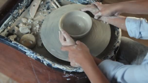 Femme enseigne à son fils à façonner un pot d'argile — Video