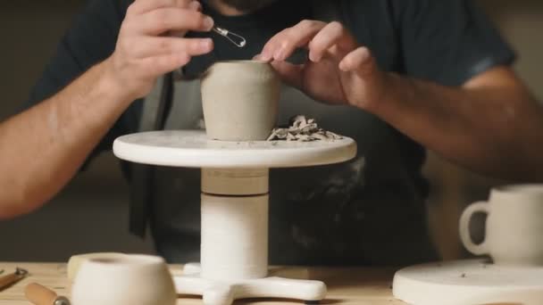 Ceramista maschio utilizzando strumenti per fare tazza di argilla ceramica in studio vasaio — Video Stock