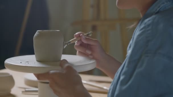 Закрытие женщин-гончаров отделкой для изготовления керамической чашки когтей в гончарной мастерской — стоковое видео