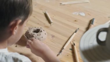 Küçük çocuğun çömlekçilik dersinde kille oynadığı arka plan.