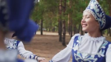 Geleneksel Rus Halk kostümlü altı genç kadın yaz ormanlarında dans ediyor.