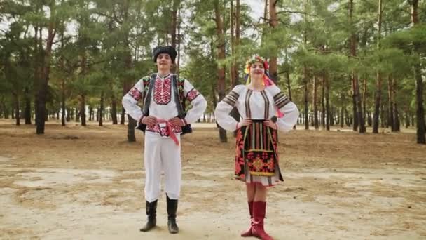 Young woman and man in traditional costumes are dancing Ukrainian national dance — Stock Video