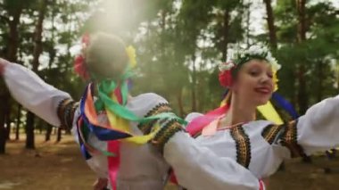 Geleneksel kostümlü iki kadın Ukrayna ulusal danslarında dans ediyor.