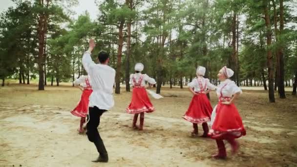 Tanzgruppe tanzt russische traditionelle Tänze im Sommerwald — Stockvideo