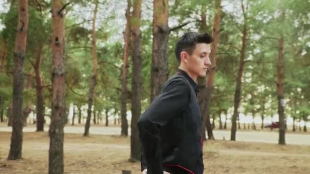 Покриття молодого чоловіка в чорному костюмі танцює традиційний іспанський танець в лісах. — стокове відео