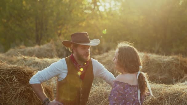 Nuori cowboy ja kaunis nainen kaunis puhuu maatilalla auringonvalo taustalla — kuvapankkivideo