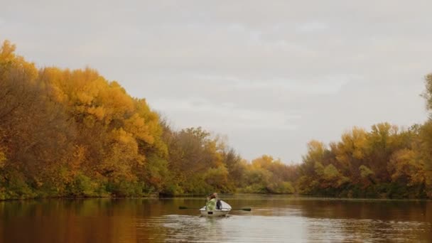 Duas mulheres bonitas se senta em um barco em um lago em uma floresta de outono fada — Vídeo de Stock