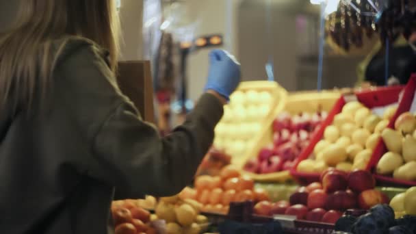Jonge vrouw doet gele appels in een papieren zak, dan geeft het aan verkoper op de markt — Stockvideo