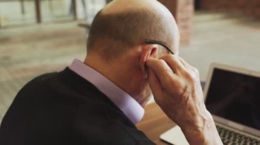 Son sınıf öğrencisi sokak kafesinde kablosuz kulaklık takıyor.