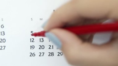 Takvimde kırmızı kalemli bir kadın el çemberi günü. İş Temel Duvar Takvimi Planlayıcı ve Düzenleyici. 5 Temmuz