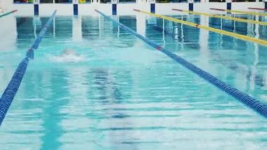 Profesyonel yüzücü, kapalı havuzda zar zor yüzüyor..