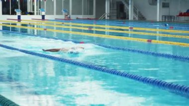 Yüzücü, kapalı havuzda zar zor yüzüyor..
