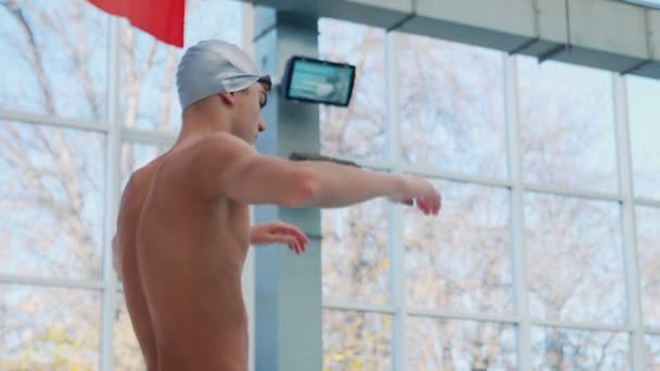 Professionale maschio nuotatore riscalda il suo corpo prima di nuotare — Video Stock