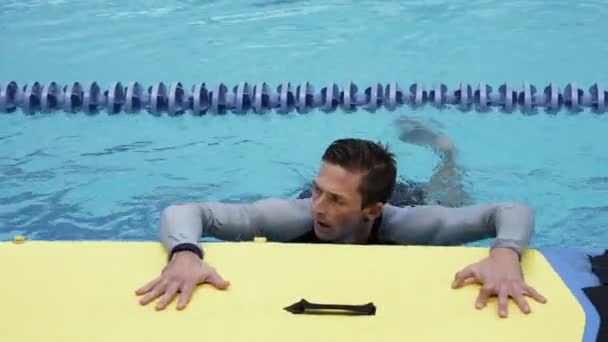 职业运动员站在游泳池的黄色冲浪板上 — 图库视频影像