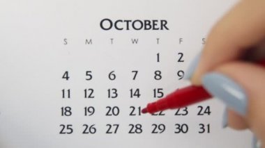 Takvimde kırmızı kalemli bir kadın el çemberi günü. İş Temel Duvar Takvimi Planlayıcı ve Düzenleyici. 22 Ekim