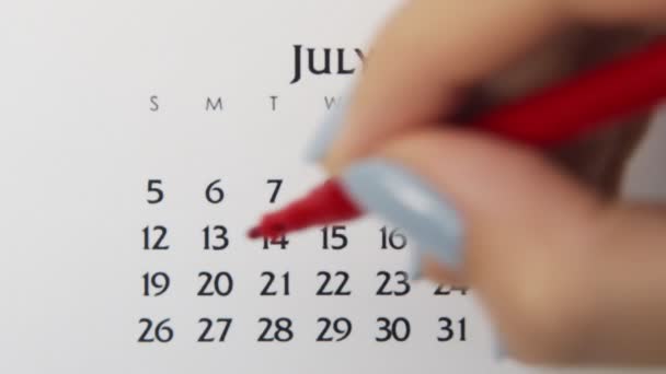 赤いマーカーでカレンダー日付の女性の手の円の日。ビジネスの基本壁カレンダープランナーと主催者。7月20日 — ストック動画