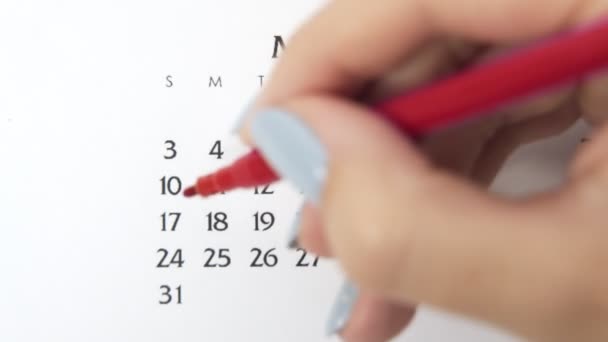 赤いマーカーでカレンダー日付の女性の手の円の日。ビジネスの基本壁カレンダープランナーと主催者。5月10日 — ストック動画
