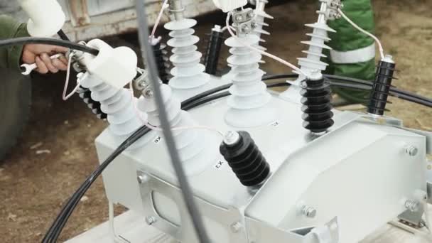 Elektriker installieren und reparieren Stromleitungen an Strommasten — Stockvideo