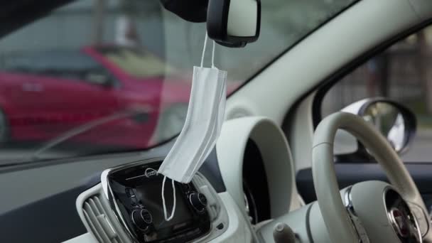 Het beschermmasker hangt aan de achteruitkijkspiegel in de auto — Stockvideo