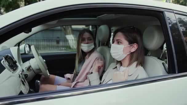 为了防止COVID-19的传播，许多年轻女性坐在车上，脸上戴着口罩. — 图库视频影像