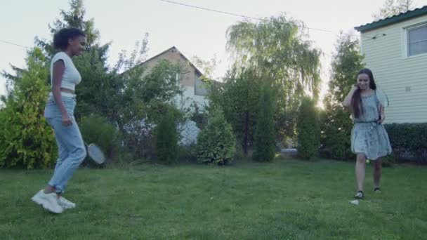 Deux jeunes femmes jouent au badminton sur une pelouse verte dans le jardin de leur maison — Video