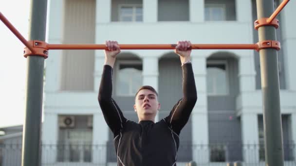 Jeune homme musclé faisant Muscle Up exercice sur la barre à l'extérieur — Video