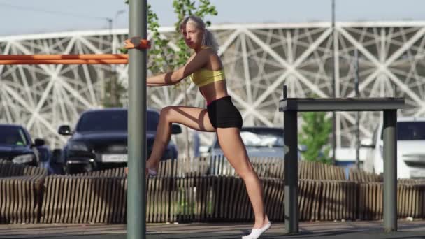 Sidovy av atletisk kvinna är sträckor och sitter på tvinnat garn — Stockvideo