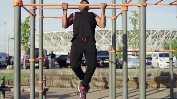 Afro άνθρωπος κάνει pull ups σε οριζόντια προπόνηση σε εξωτερικούς χώρους — Αρχείο Βίντεο