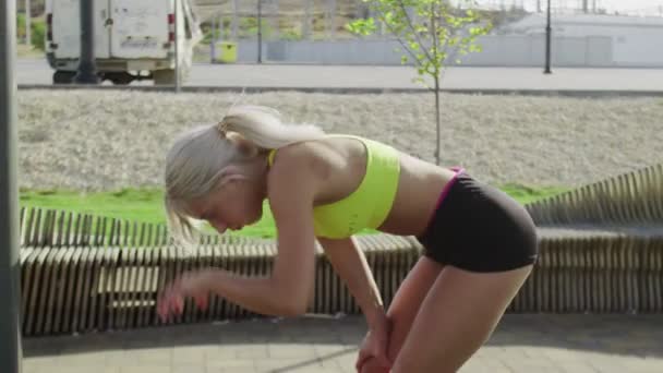 젊은 여자 운동 선수가 집 밖에서 힘든 훈련을 받은 후에 숨을 깊이들이 쉰 다 — 비디오