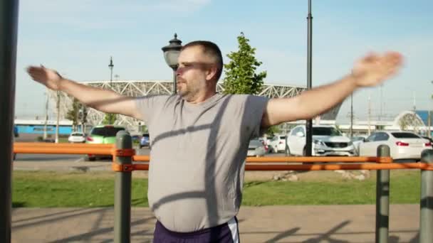 Homme âgé en t-shirt gris qui se réchauffe à l'extérieur — Video