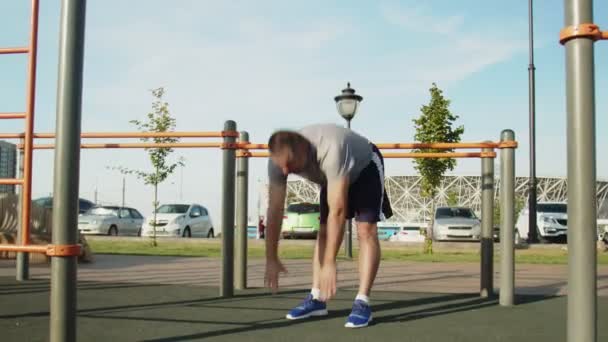 Homme âgé en t-shirt gris qui se réchauffe à l'extérieur — Video