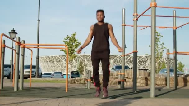 Bonito desportivo afro homem exercitando com corda de salto ao ar livre — Vídeo de Stock