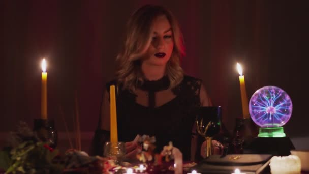 Female charlatan Witch or fortune teller cant lights a candle for rituals — Stock Video