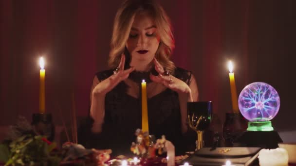 Žena věštkyně pohybující ruce nad kouzelnou svíčku — Stock video