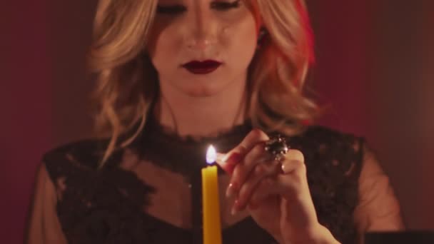 점쟁이 여성을 가까이 서 보면 마법의 촛불을 밝히고 그 위로 손을 얹는다 — 비디오