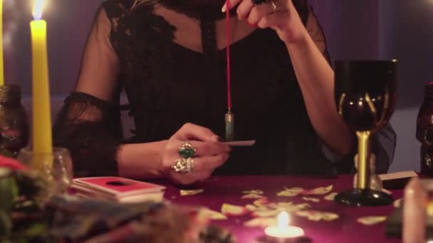 Close up of female fortune teller holding a magic pendulum over photo of lost person — Stock Video