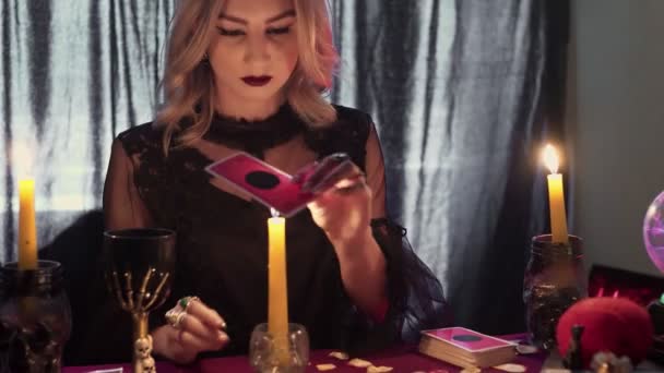Női jövendőmondó mágikus taro kártyát pakol egy gyertya fölé. — Stock videók