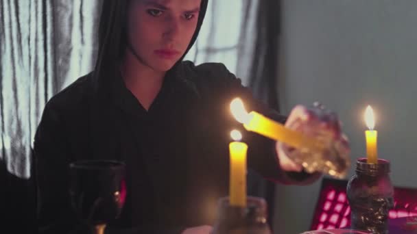 Мужчина колдунья экстрасенс зажигает свечу для ритуалов — стоковое видео
