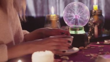 Kadın falcı kahveyi fal baktırmak için müşterisine kahve verir.