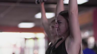 Jimnastik salonunda sivilceli sarışın kadınların yan görünüşü.