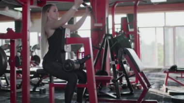 Sarışın kadın jimnastik salonunda egzersiz yapıyor.