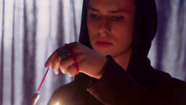 Detailní záběr mága, jak otáčí kouzelným kyvadlem nad svíčkou — Stock video